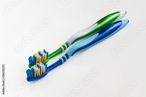 Two new toothbrushes  green and blue on a light background