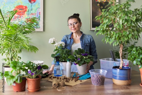 Woman caring for potted plants, replanting, fertilizing.