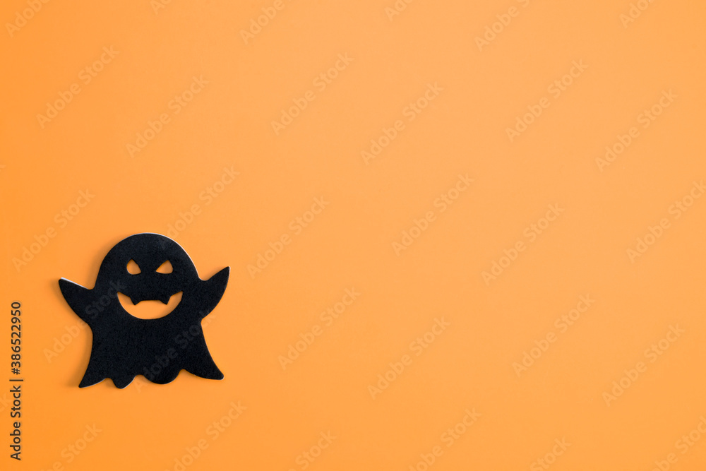 Halloween. Black ghost on an orange background. Halloween concept.