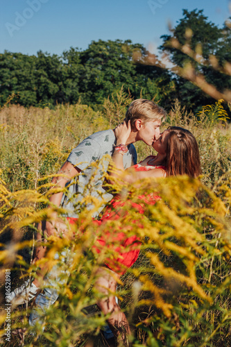 Couple kissing in the middle of the field.