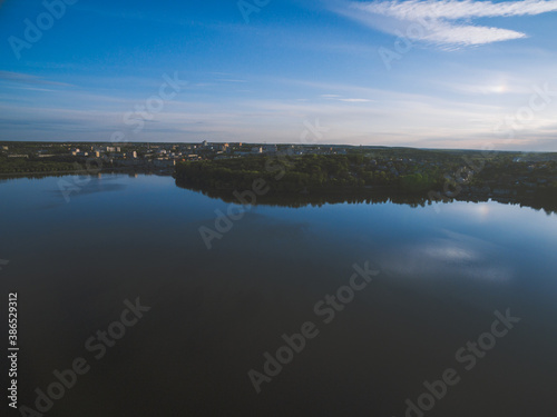 Sunset over a river with forest and a city on horizon. Almost dusk.