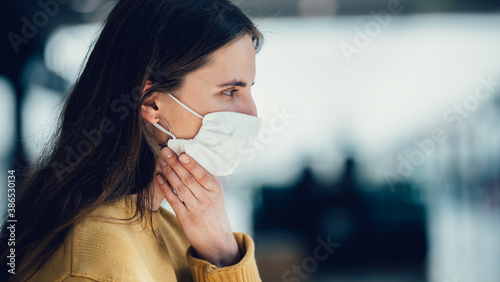 young woman in a protective mask looking at you