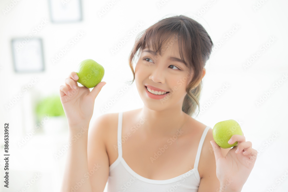 Beautiful portrait young asian woman holding and eating green apple fruit in the bedroom at home, lifestyle of nutrition girl healthy and care weight loss, health and wellness concept. Beautiful portrait young asian woman holding and eating green apple fruit in the bedroom at home, lifestyle of nutrition girl healthy and care weight loss, health and wellness concept.