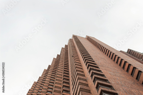 Low Angle view of a brick corner geometrical building with blue cloudy sky at sunny day