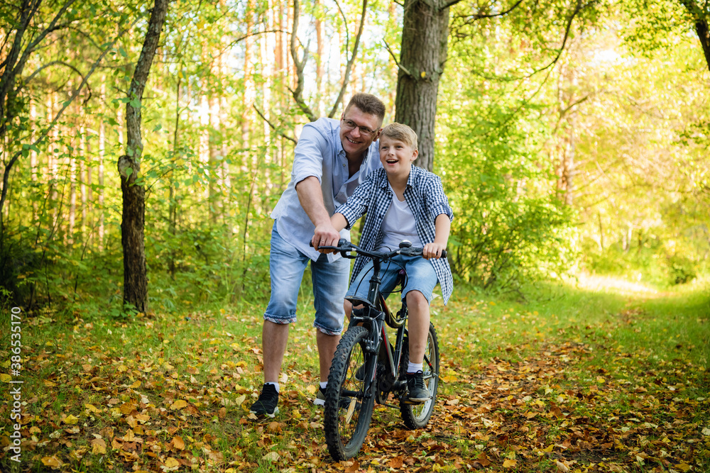 Naklejka premium Father Teaching Son To Ride Bike In Countryside