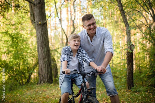 Father Teaching Son To Ride Bike In Countryside © romankosolapov