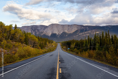 View of Scenic Road surrounded by Trees and Rocky Mountains on a Cloudy Fall Day in Canadian Nature. Taken near Whitehorse, Yukon, Canada. © edb3_16