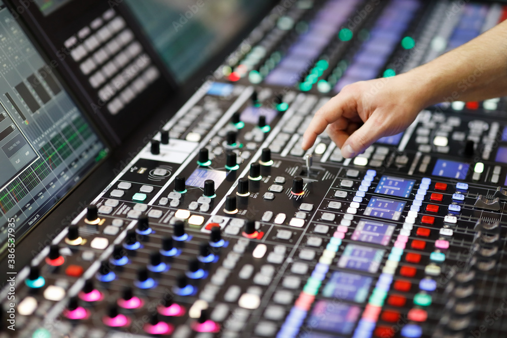 operator adjusts controls of audio mixer panel operator adjusts controls of audio mixer panel