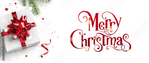 Merry Christmas text on white background with gift boxes  ribbons  red decoration  fir branches  bokeh  sparkles and confetti. Xmas and New Year greeting card  bokeh  light. Flat lay  top view  banner