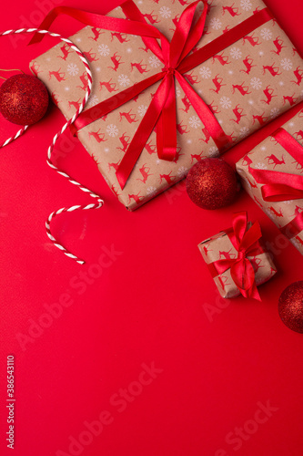 christmas gifts with red ribbon and red christmas balls on red background.