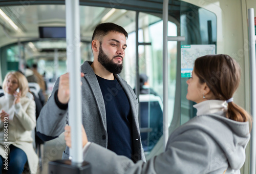 Happy passengers flirting in subway and smiling. High quality photo