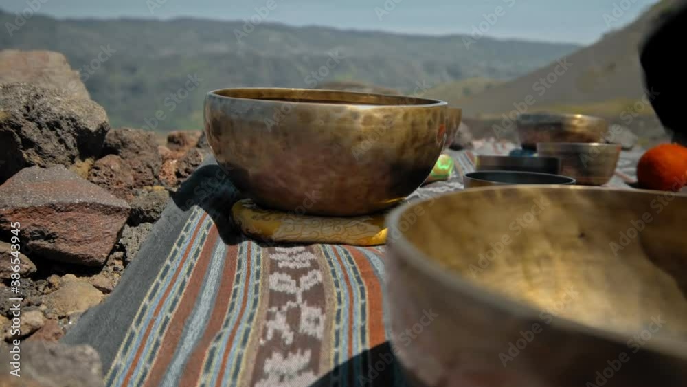 Asian guy playing Tibedt singing copper cups on a viewing mountain Asian guy playing Tibedt singing copper cups on a viewing mountain