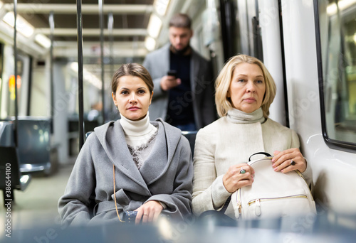Two women in the cabin of city bus. High quality photo