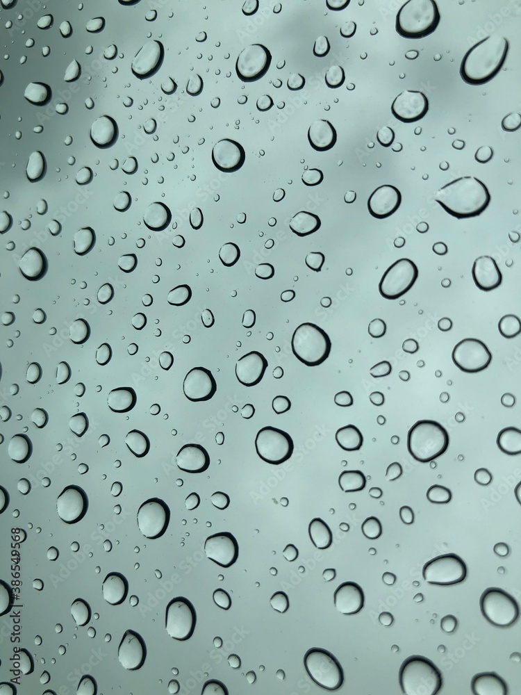 Image of water droplets on a clear glass surface during heavy rain. Image of water droplets on a clear glass surface during heavy rain.