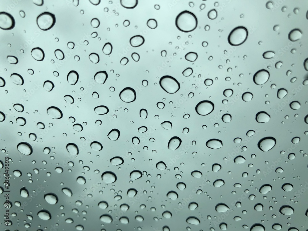 Image of water droplets on a clear glass surface during heavy rain. Image of water droplets on a clear glass surface during heavy rain.
