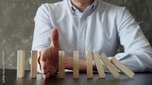 Businessman Stop Domino Effect. Risk Management and Insurance Concept.
