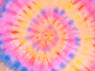 Spiral tie dye wallpaper. Hippie tie-dye background. Tiedye backdrop. Psychedelic tie dye pattern in yellow blue red. 