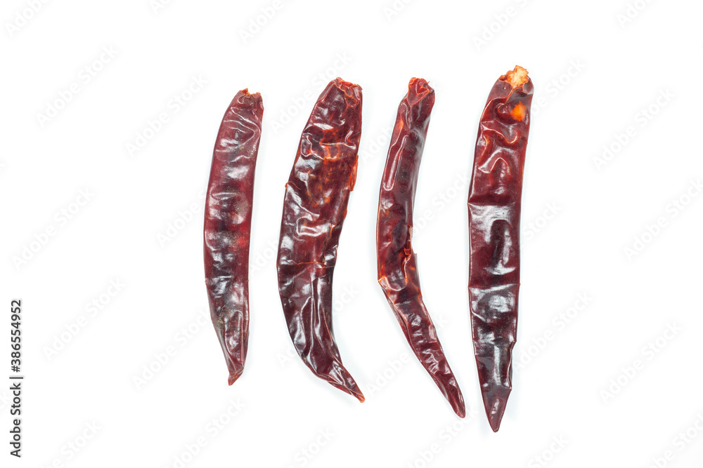 Dried red chili of various sizes placed in a row isolated on white background. Dried red chili of various sizes placed in a row isolated on white background.