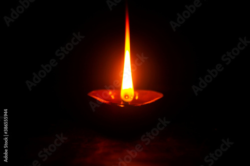 Diwali Diya in black. Deepam oil lamp. Flame in dark. a light powered by coconut oil. photo