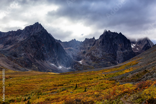 Beautiful View of Dramatic Mountains and Valley during Fall in Canadian Nature. Aerial Shot. Taken in Tombstone Territorial Park, Yukon, Canada.