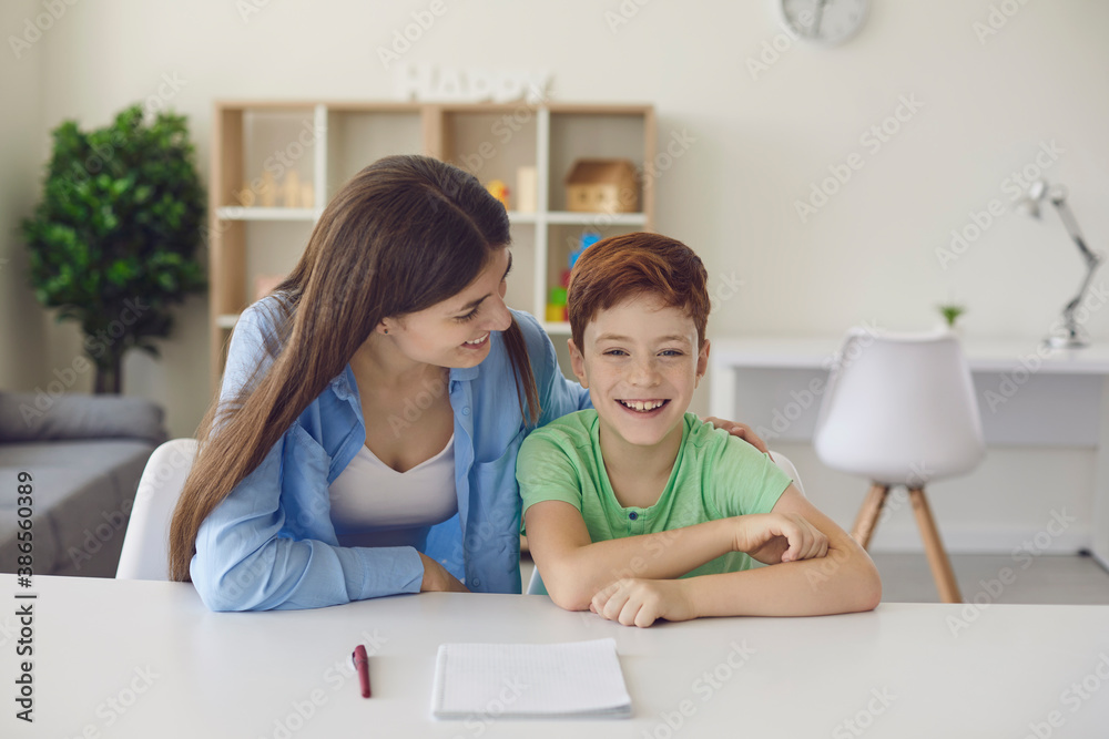 Little boy is going to write down tasks on a piece of paper with the help of his mother. Little boy is going to write down tasks on a piece of paper with the help of his mother.