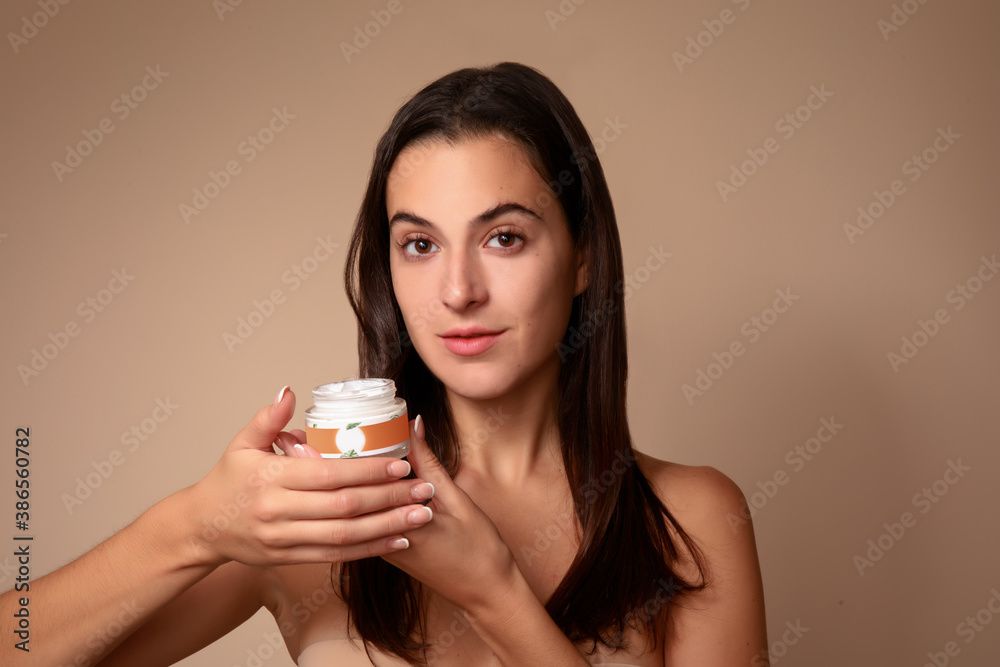 © Gener Vázquez - Joven Mujer mexicana mostrando crema humectante facial producto de belleza feliz sonriente