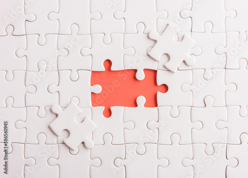 Top view flat lay of paper plain white jigsaw puzzle game texture last pieces for solve and place, studio shot on a red background, quiz calculation concept