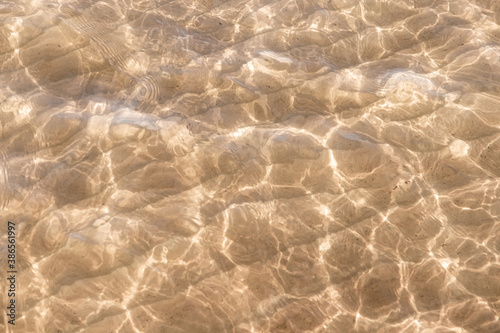 Sandy seabed under shallow water with refraction lines