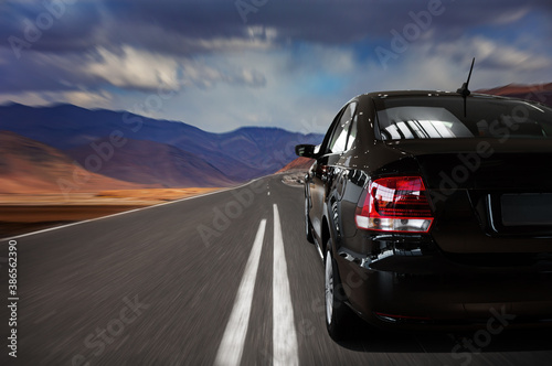 Close-up of a black car on the highway. travel by car. high-speed road along the mountains