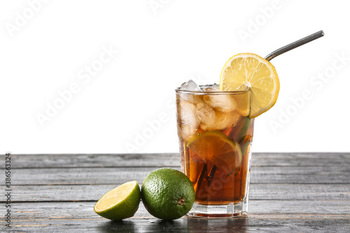 Photography Glass of tasty Cuba Libre cocktail on table against white background