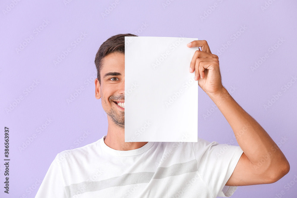 Young man with blank paper sheet on color background