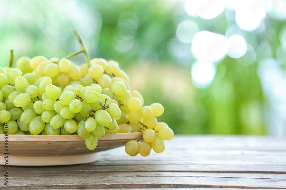 Plate with ripe grapes on table outdoors Plate with ripe grapes on table outdoors