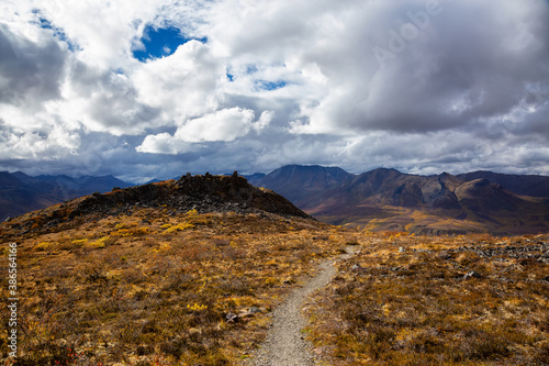 View of Scenic Hiking Trail on top of a Mountain on a Sunny Fall Day in Canadian Nature. Taken in Tombstone Territorial Park, Yukon, Canada. photo