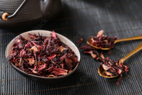 Bowl with dry hibiscus tea on table