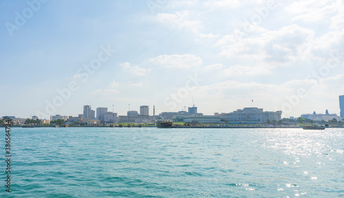 Dhows moored off Museum Park in central Doha, Qatar, with some of the buildings from the city's commercial port in the background.