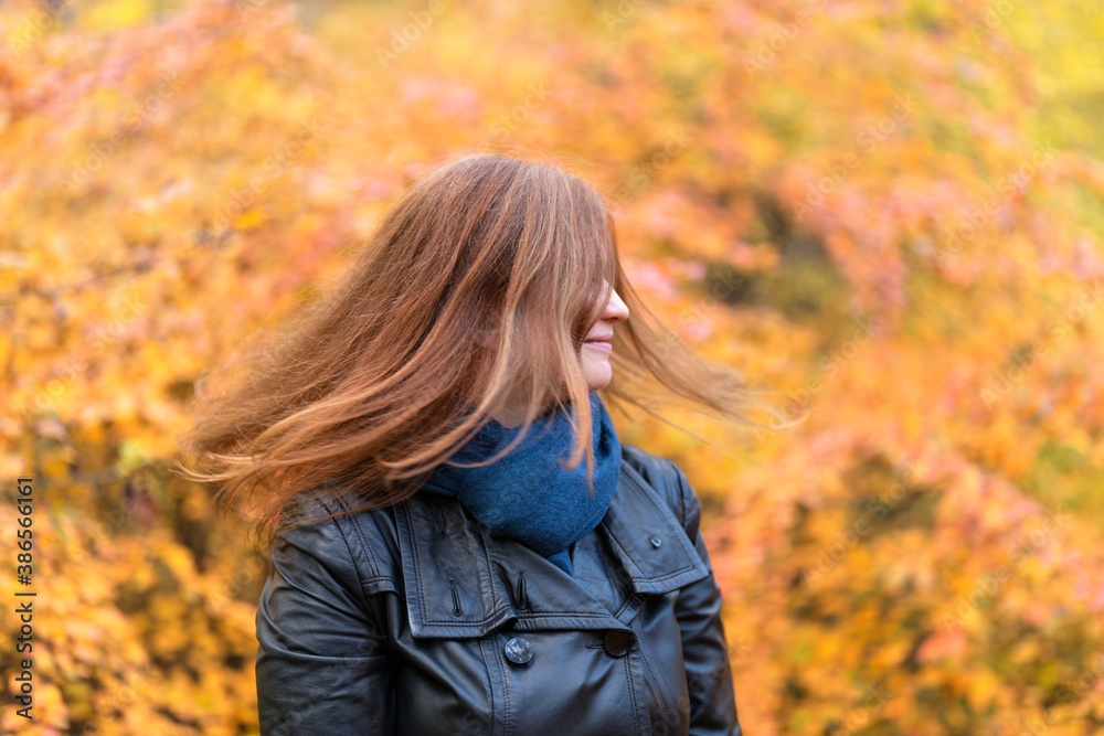 .Woman and autumn. Red-haired girl waves her hair against the background of the autumn forest. .Woman and autumn. Red-haired girl waves her hair against the background of the autumn forest.