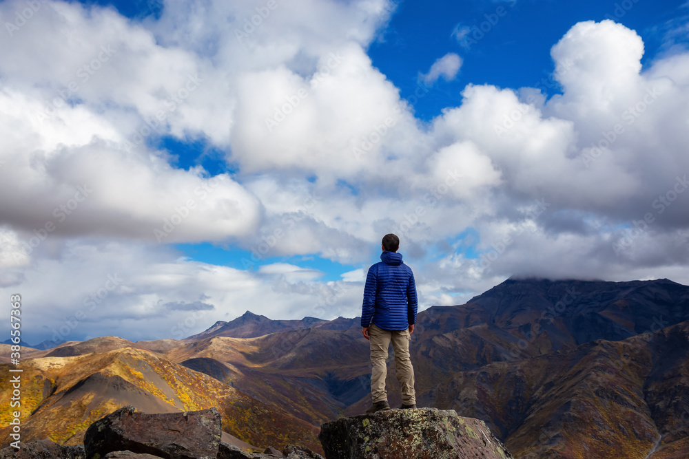 Man Standing and Looking at Viewpoint of Mountain Range on a Cloudy Fall Day in Canadian Nature. Taken in Tombstone Territorial Park, Yukon, Canada.