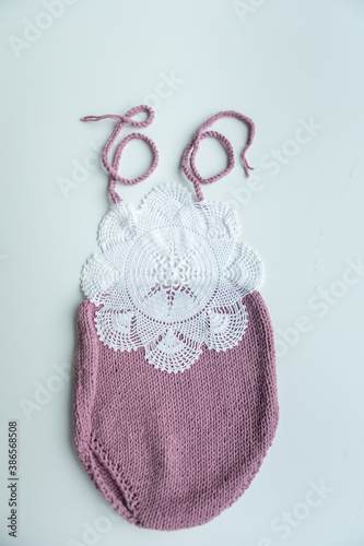 Various colors and types of cotton clothing, knitted newborn clothes and newborn hats on a white background.