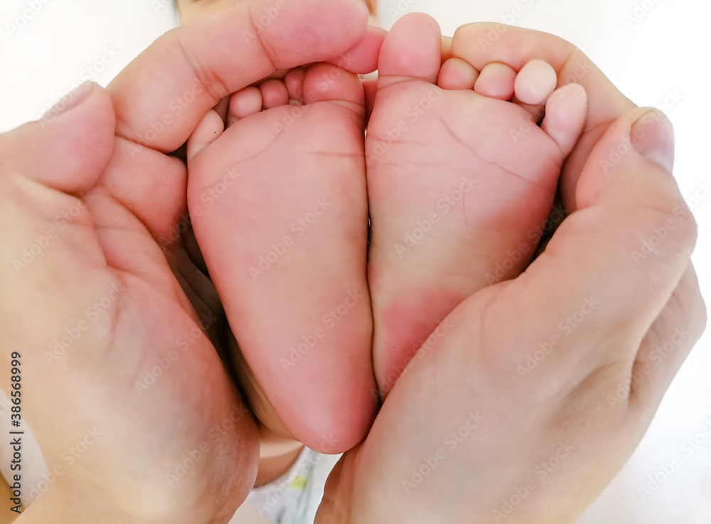 Baby feet in mother hands. Tiny Newborn Baby's feet on female Shaped hands closeup. Mom and her Child. Happy Family concept. Beautiful conceptual image of Maternity Baby feet in mother hands. Tiny Newborn Baby's feet on female Shaped hands closeup. Mom and her Child. Happy Family concept. Beautiful conceptual image of Maternity