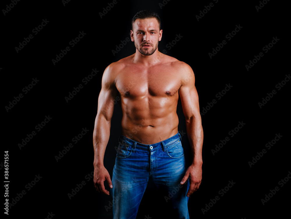 Fototapeta premium Muscular shirtless fashion male model. Strong man. Guy in vogue style on a black background. Young businessman. Athlete from a beautiful body. Beautiful young mans naked torso.
