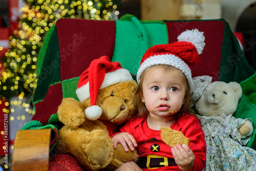 Little baby in Santa hat celebrates Christmas. Infant in New Year cap.