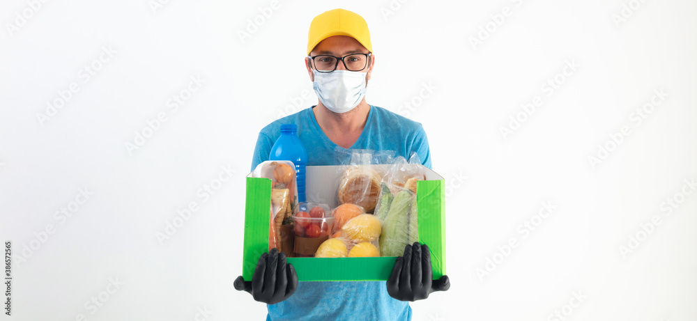 Delivery guy with protective mask holding box with groceries. Delivery guy with protective mask holding box with groceries.