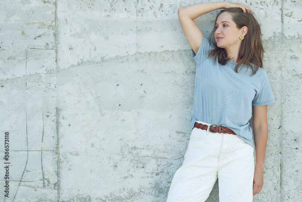 Portrait of cheerful mature woman standing against grey wall. Smiling carefree woman looking at camera. High quality photo. Portrait of cheerful mature woman standing against grey wall. Smiling carefree woman looking at camera. High quality photo.