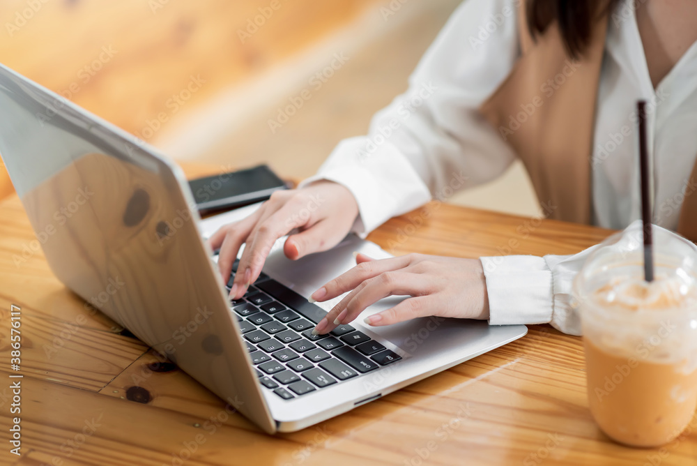 Close up. Woman sitting at desk and working at laptop computer. Close up. Woman sitting at desk and working at laptop computer.