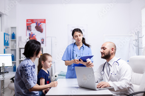 Doctor holding pills bottle during child consultation in home office. . Healthcare physician specialist in medicine providing health care services treatment examination.