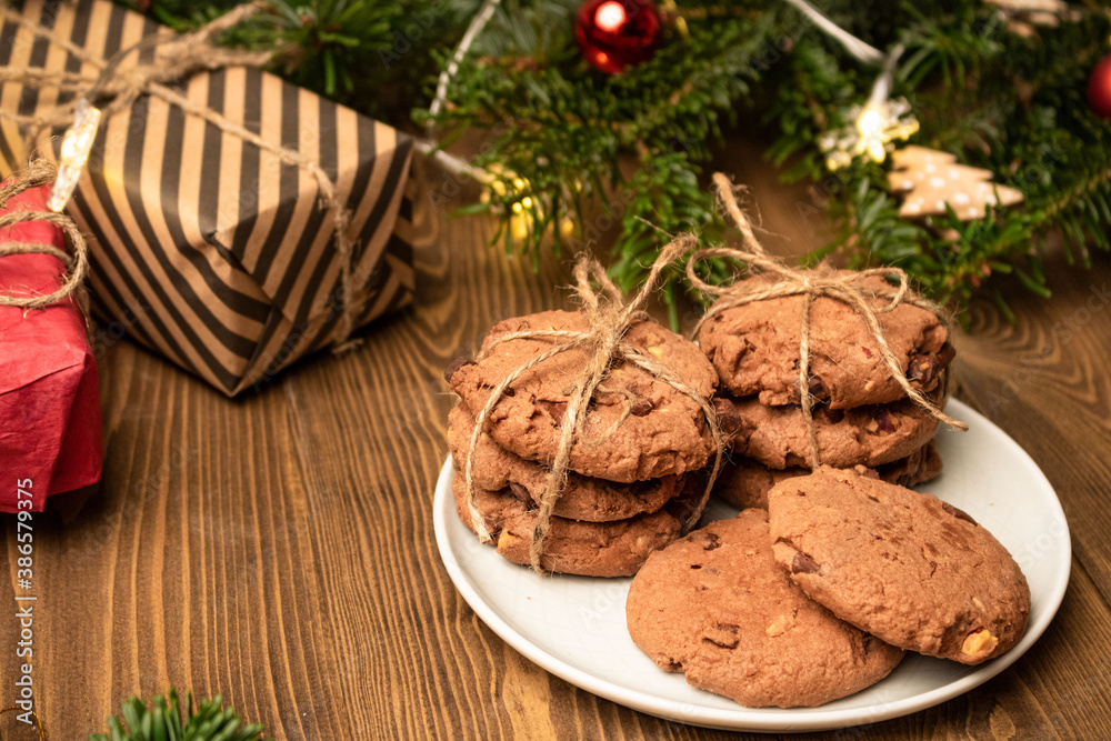 Fototapeta premium Cookies, gift boxes and a spruce branch on a wooden table. Side view.