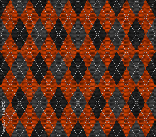 Knitted argyle Halloween pattern. Wool knitinng. Scottish plaid in orange, black and grey rhombuses. Traditional  Scottish background of diamonds . Seamless fabric texture. Vector illustration