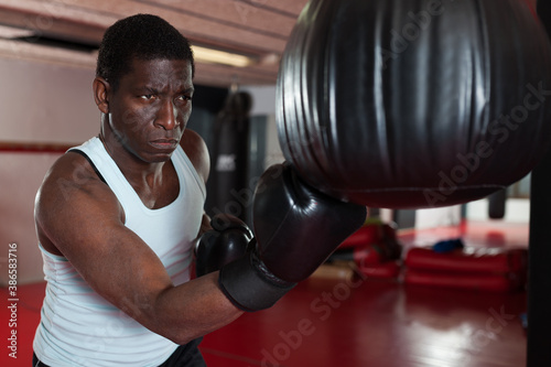 Confident afro american boxer holds training in the ring. High quality pot © JackF