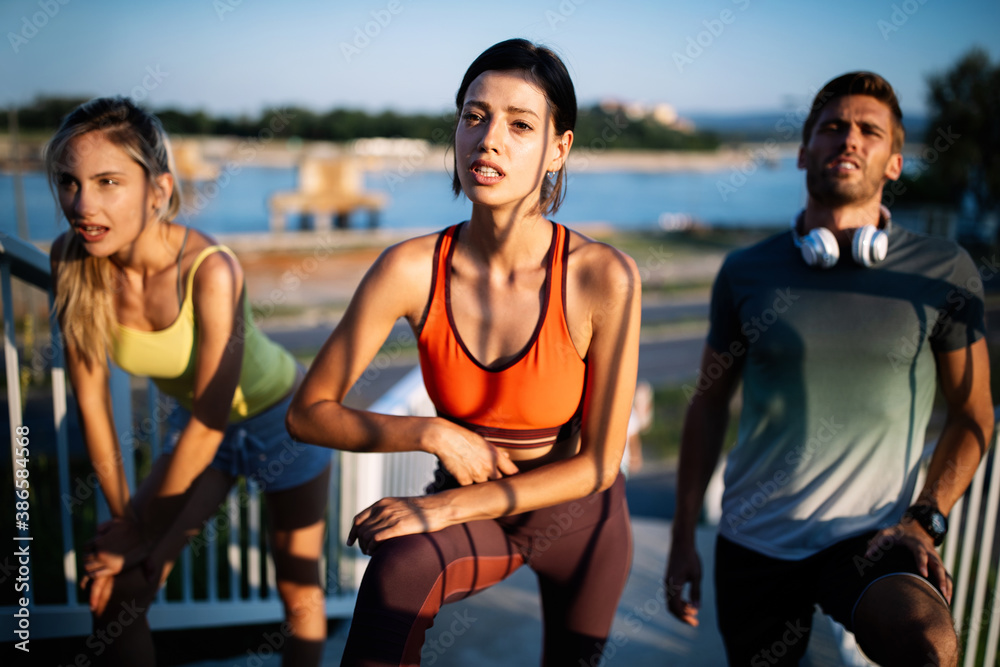 Outdoor portrait of group of friends running and exercising in city Outdoor portrait of group of friends running and exercising in city