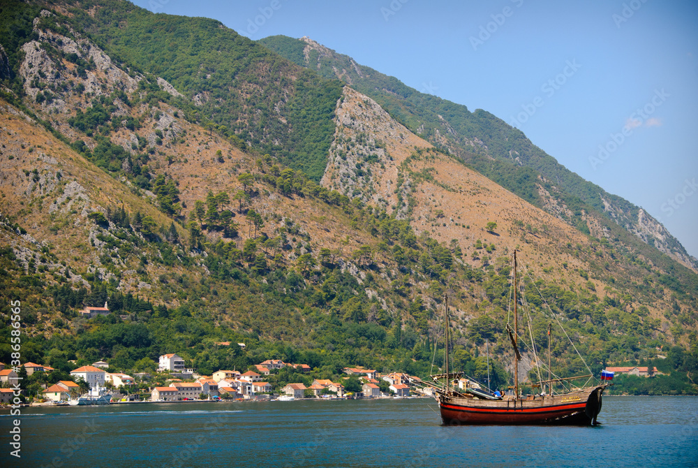 Wooden single-masted ship anchored in the bay